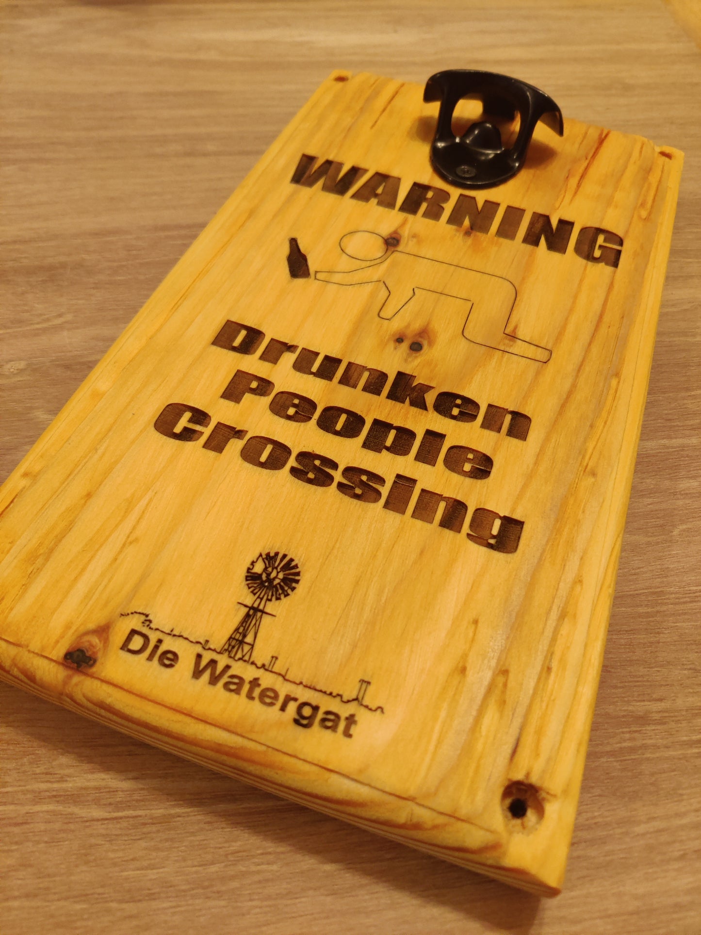 Muurgemonteerde flesopener met magnetische dopvanger en "Drunken People Crossing"