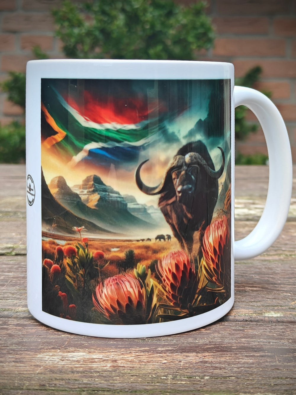 Mug with Buffalo and Proteas , featuring a landscape with the Drakensberg mountains and the South African flag - dieWatergat.nl