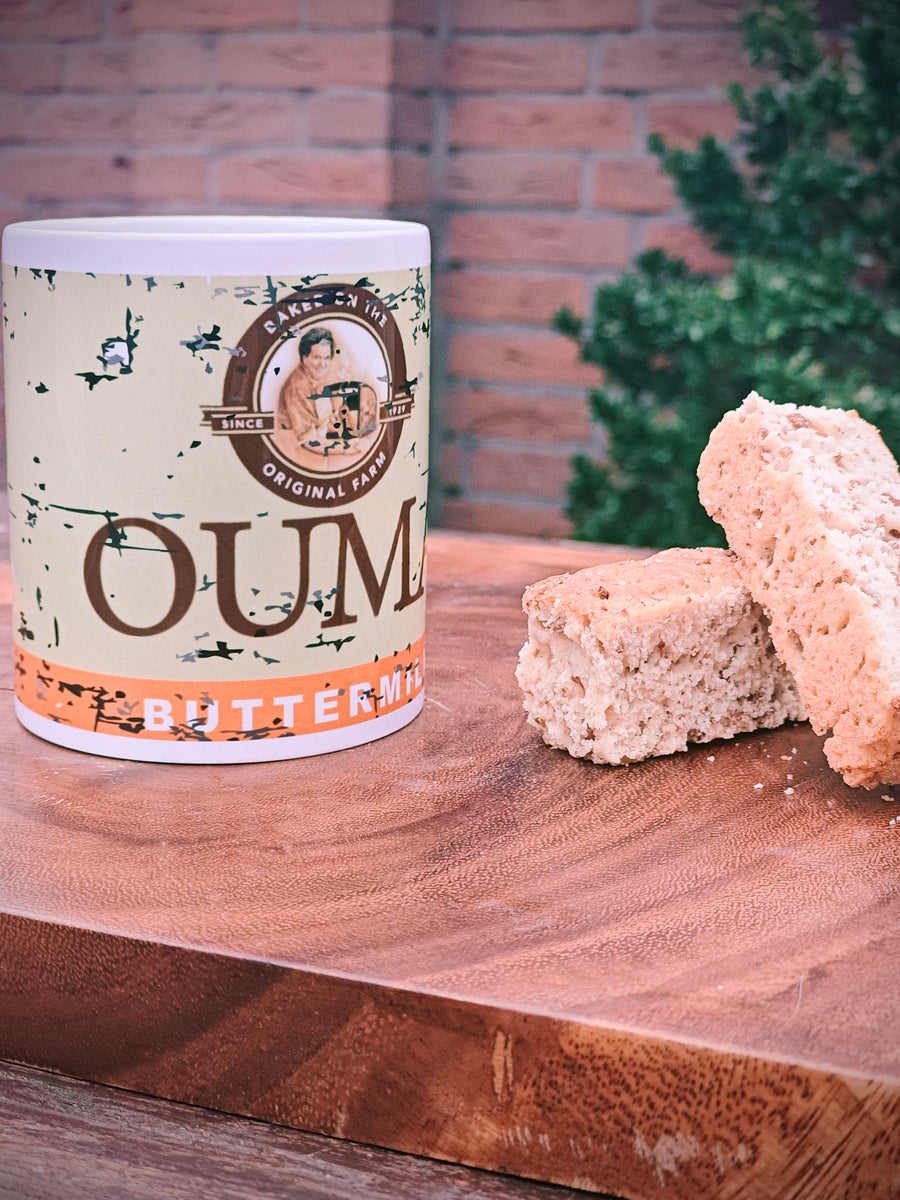 Ouma Buttermilk Rusk Mug on a wooden surface with two Rusks.