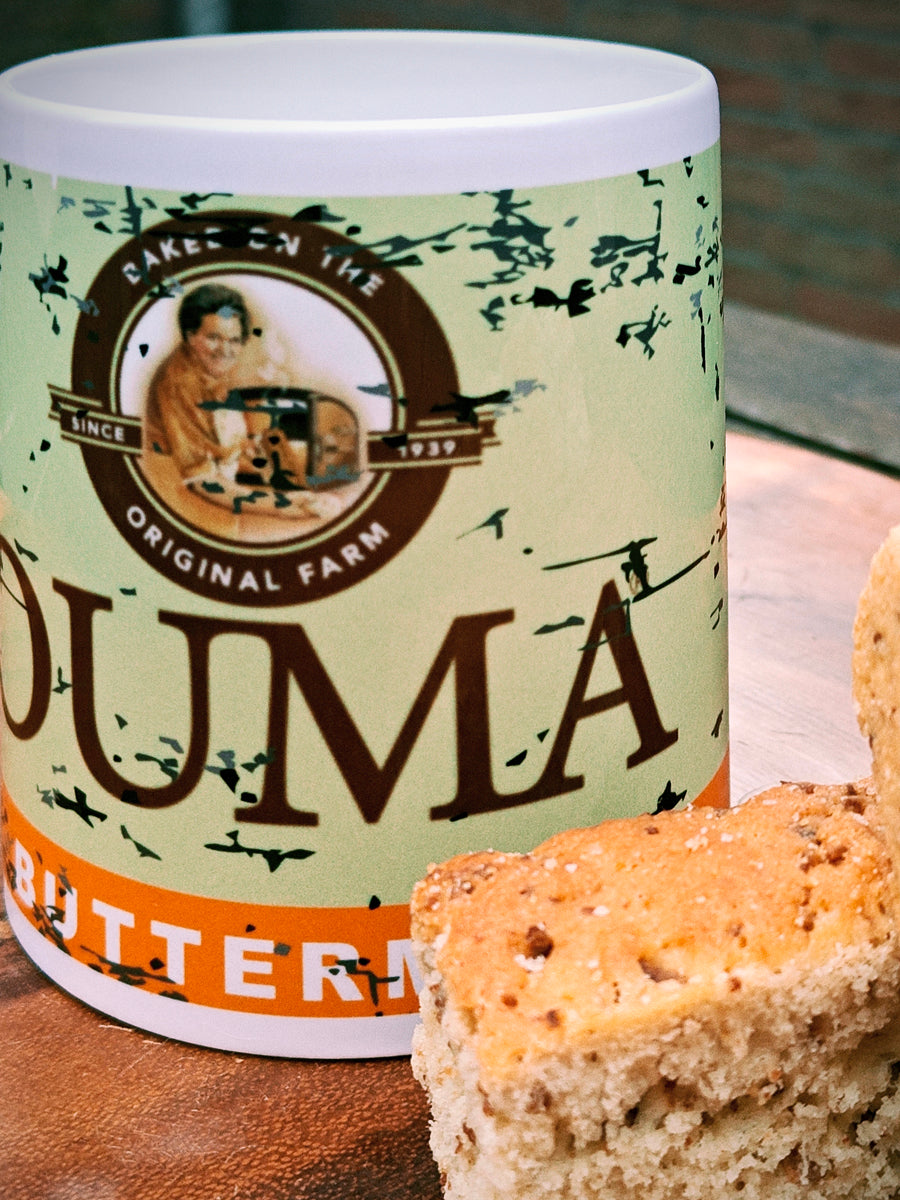 Ouma Buttermilk Rusk Mug on a wooden surface with two Rusks.