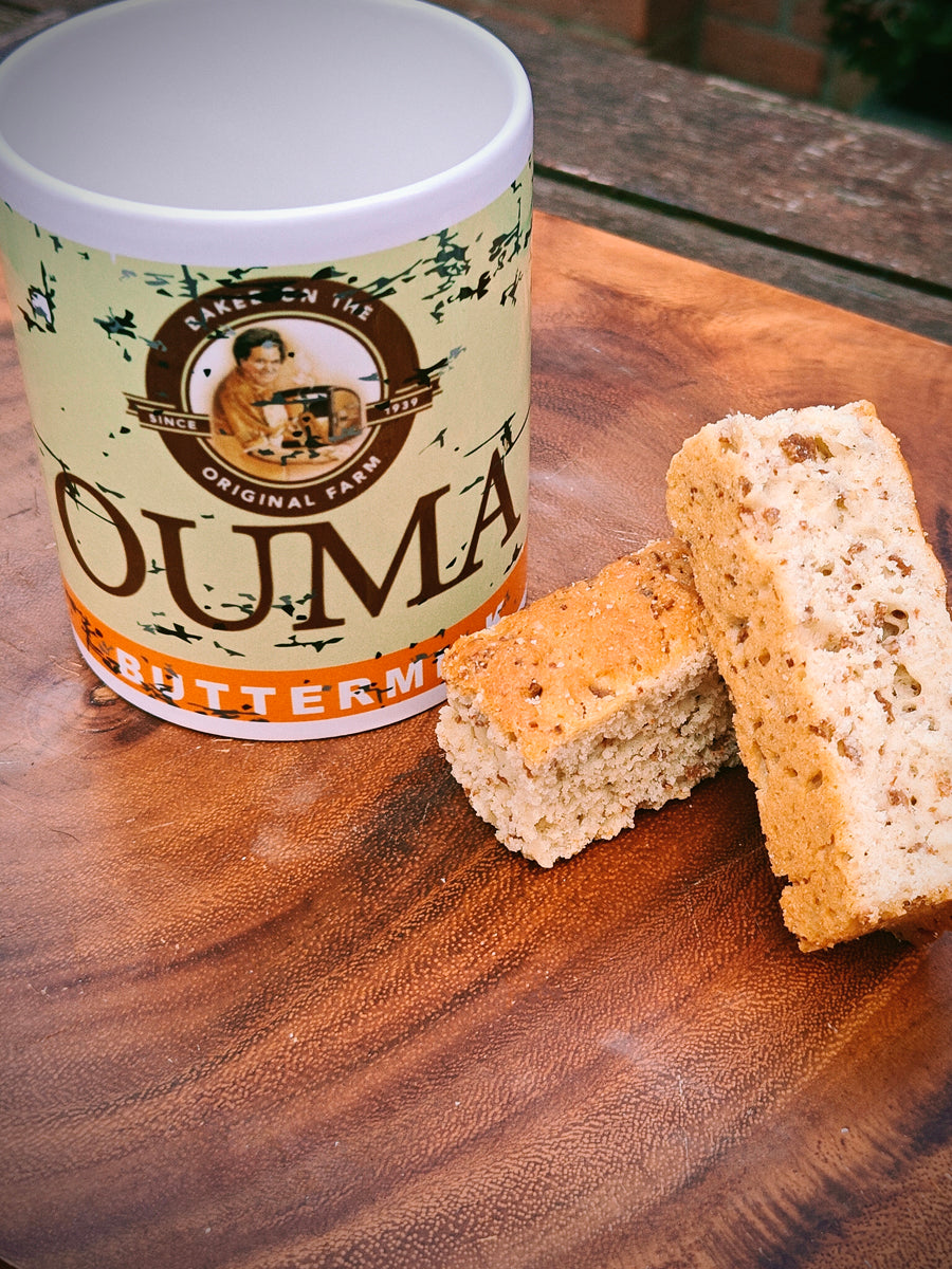 Ouma Buttermilk Rusk Mug on a wooden surface with two Rusks.