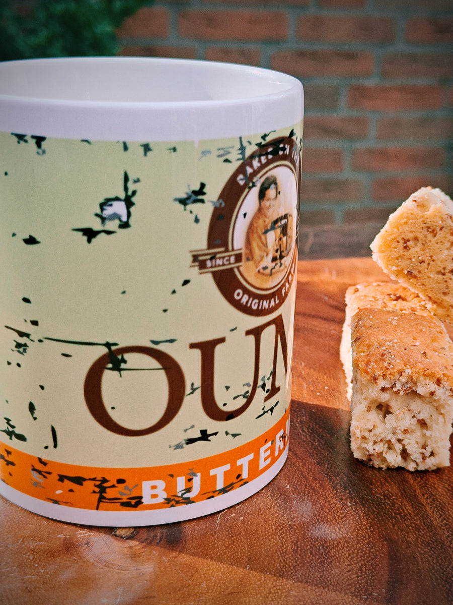 Ouma Buttermilk Rusk Mug on a wooden surface with two Rusks.